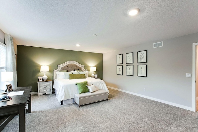bedroom featuring carpet flooring, a textured ceiling, visible vents, and baseboards