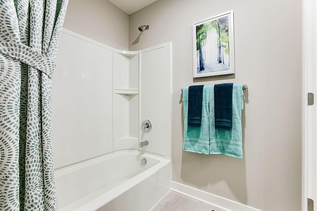 full bathroom with shower / bath combo, tile patterned flooring, and baseboards