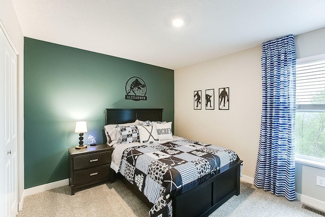 bedroom featuring baseboards, visible vents, a closet, and light colored carpet