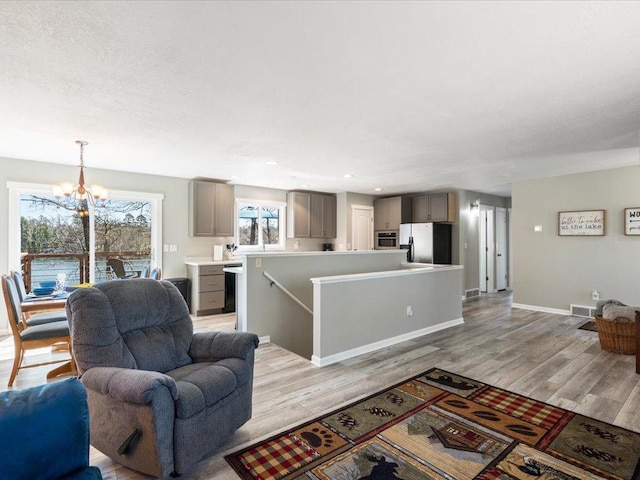 living area featuring visible vents, recessed lighting, light wood-style floors, and a chandelier