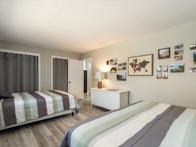 bedroom featuring a textured ceiling and light wood-type flooring