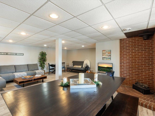 interior space with decorative columns, a drop ceiling, and wood finished floors