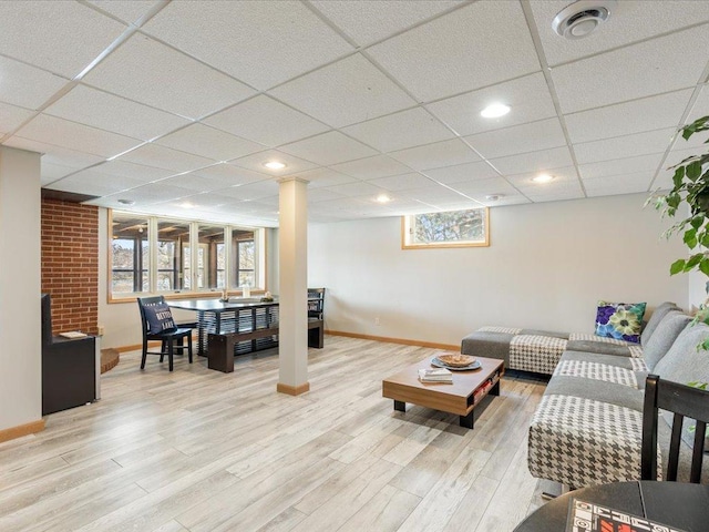 living room featuring baseboards, a paneled ceiling, wood finished floors, and visible vents