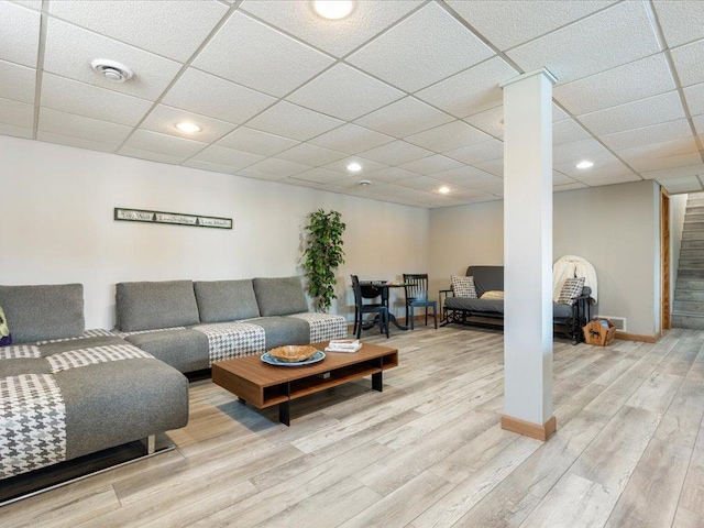 living area featuring a drop ceiling, recessed lighting, and wood finished floors