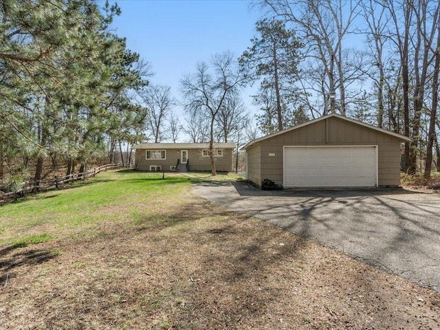 exterior space featuring a garage, board and batten siding, an outbuilding, and a front yard