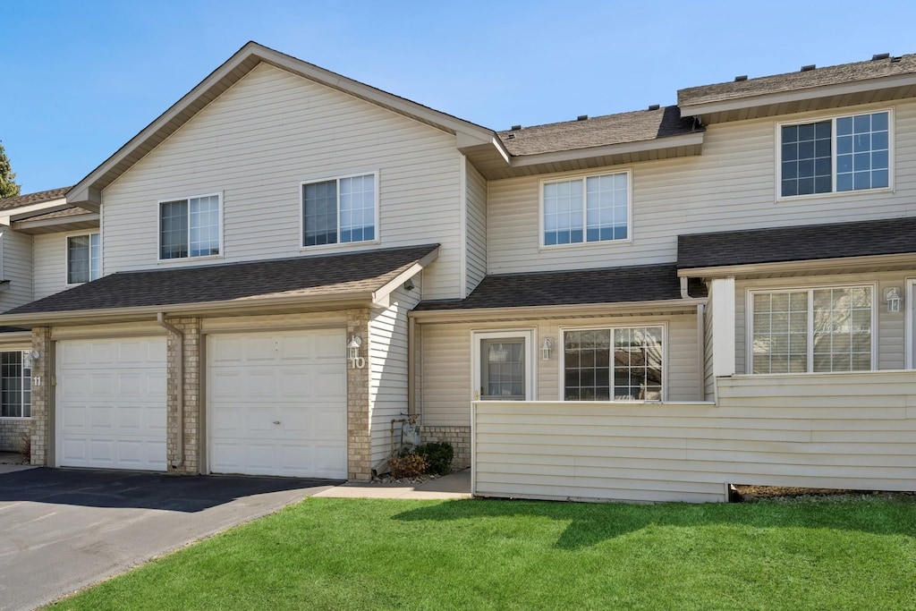 2775 Ranchview Ln N Unit 10, Plymouth, MN 55447 - townhome / multi-family property featuring roof with shingles, an attached garage, driveway, and a front lawn