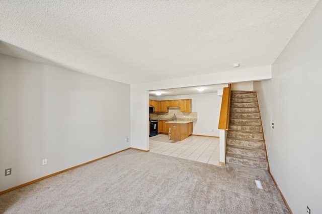 unfurnished living room with light carpet, a textured ceiling, baseboards, light tile patterned floors, and stairway