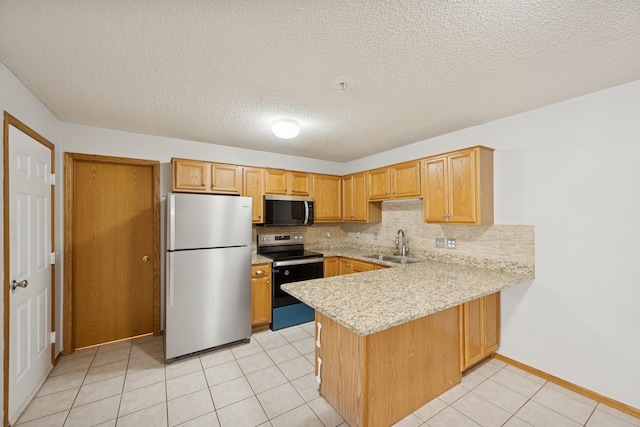 kitchen with backsplash, a textured ceiling, a sink, a peninsula, and stainless steel appliances