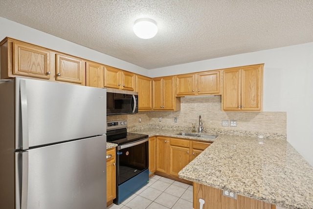 kitchen featuring a textured ceiling, appliances with stainless steel finishes, tasteful backsplash, a sink, and a peninsula