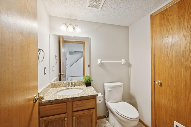half bath with vanity, toilet, a textured ceiling, and visible vents