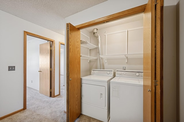 clothes washing area with independent washer and dryer, a textured ceiling, laundry area, and light colored carpet