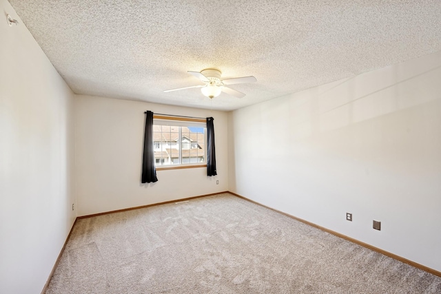 spare room featuring baseboards, ceiling fan, light carpet, and a textured ceiling