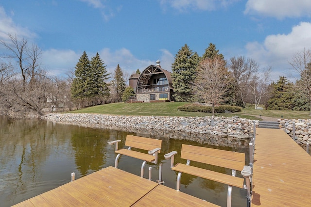 view of dock with a lawn and a water view