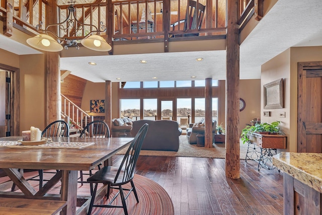 dining space with recessed lighting, a high ceiling, stairs, and dark wood-style floors