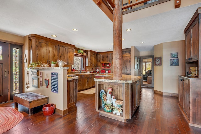 kitchen with recessed lighting, a kitchen island, dark wood finished floors, and decorative columns