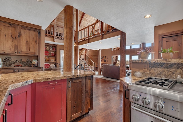 kitchen with a textured ceiling, dark wood-style flooring, open floor plan, recessed lighting, and high vaulted ceiling