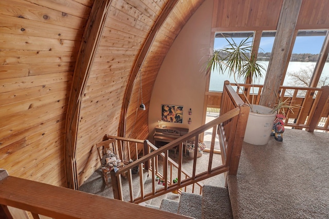 stairs with a healthy amount of sunlight, a water view, and carpet flooring