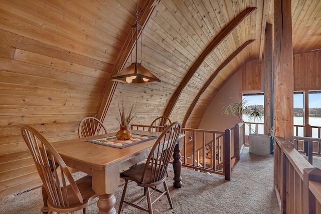 dining room with wooden ceiling, vaulted ceiling with beams, wood walls, and carpet