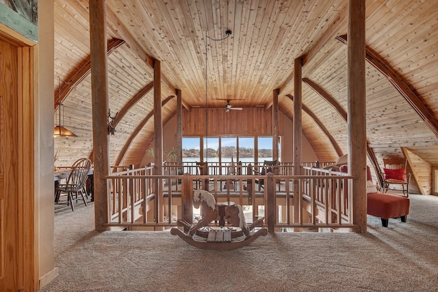 additional living space with lofted ceiling with beams, a water view, wooden ceiling, carpet, and a ceiling fan