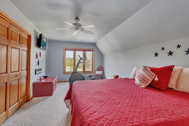 bedroom with a closet, light carpet, baseboards, a ceiling fan, and lofted ceiling