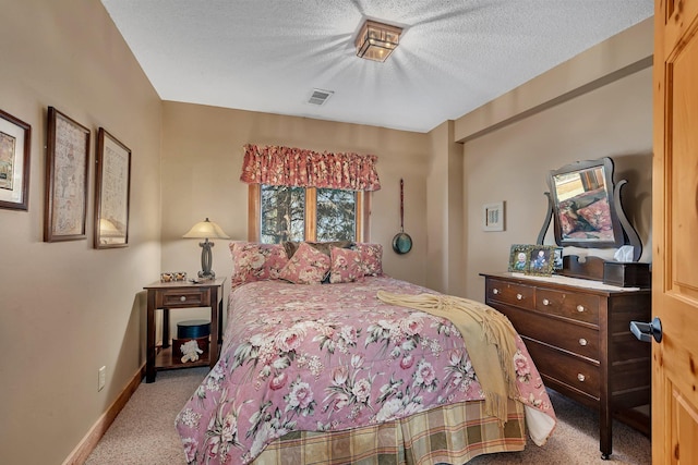 bedroom with a textured ceiling, visible vents, baseboards, and carpet floors