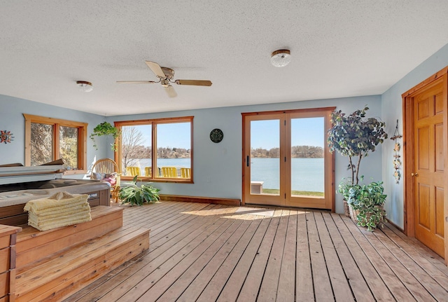interior space featuring ceiling fan, french doors, an indoor hot tub, and a water view
