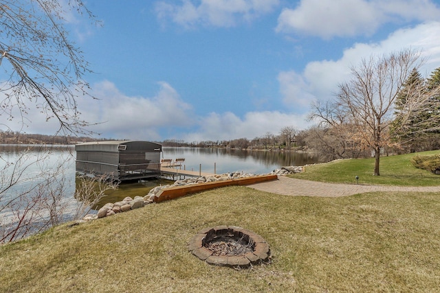 dock area featuring a lawn, a water view, and an outdoor fire pit