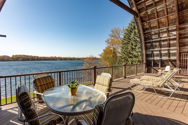 wooden deck featuring outdoor dining space and a water view