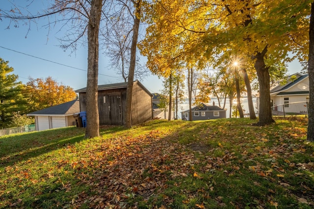 884 White Clover Beach Rd, Detroit Lakes, MN 56501 - view of yard featuring a detached garage, fence, and an outbuilding