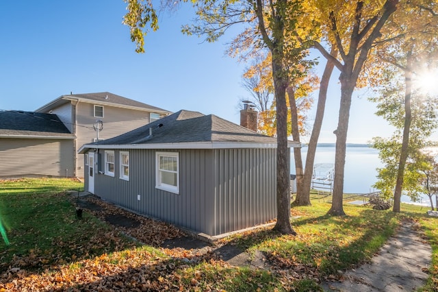 884 White Clover Beach Rd, Detroit Lakes, MN 56501 - view of home's exterior with a water view, a chimney, and a shingled roof
