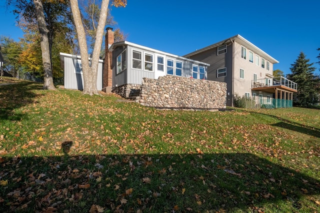 884 White Clover Beach Rd, Detroit Lakes, MN 56501 - view of side of home featuring a lawn and a chimney