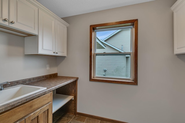 103 Grandview Ct, Buffalo, MN 55313 - kitchen with a sink, white cabinetry, dark countertops, and baseboards