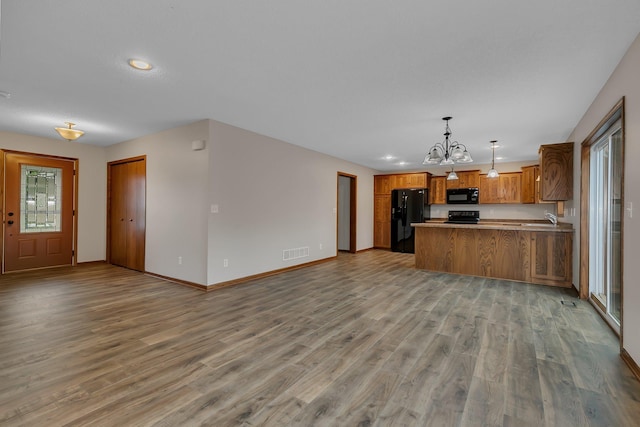 103 Grandview Ct, Buffalo, MN 55313 - kitchen with black appliances, open floor plan, a sink, brown cabinetry, and a chandelier