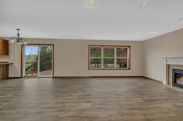 103 Grandview Ct, Buffalo, MN 55313 - unfurnished living room with baseboards, a tile fireplace, wood finished floors, a chandelier, and recessed lighting