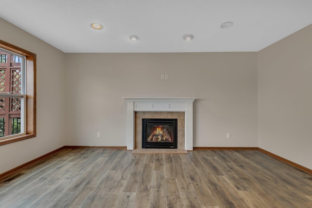 103 Grandview Ct, Buffalo, MN 55313 - unfurnished living room featuring wood finished floors, baseboards, a tiled fireplace, and recessed lighting