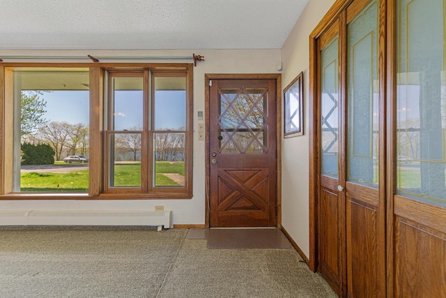 doorway with a baseboard heating unit and carpet