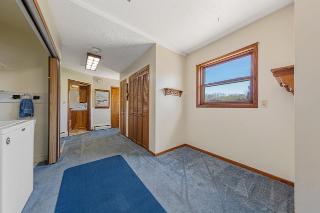 corridor with carpet flooring, a textured ceiling, baseboards, and a baseboard heating unit