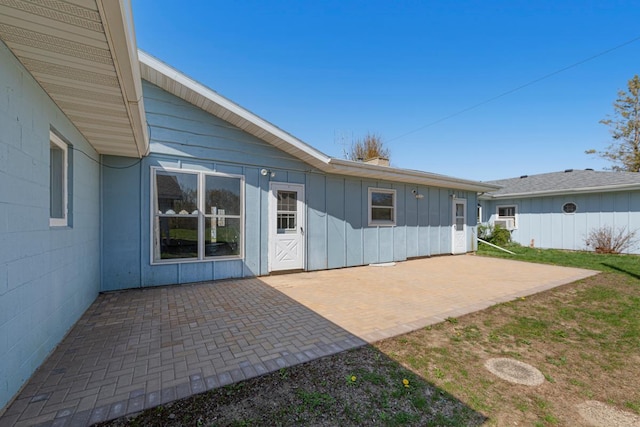 rear view of house with a patio area and board and batten siding