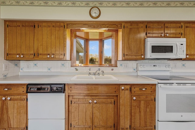 kitchen featuring white appliances, a sink, brown cabinetry, light countertops, and decorative backsplash
