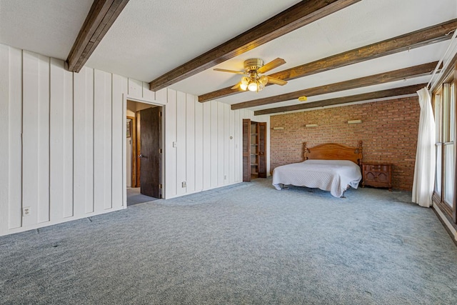 carpeted bedroom with beam ceiling, ceiling fan, and brick wall