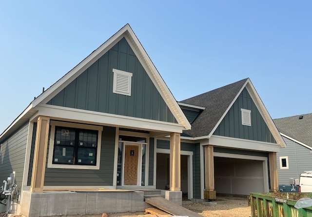 4029 Arbor Dr, Woodbury, MN 55129 - view of front of home featuring board and batten siding, covered porch, roof with shingles, and a garage