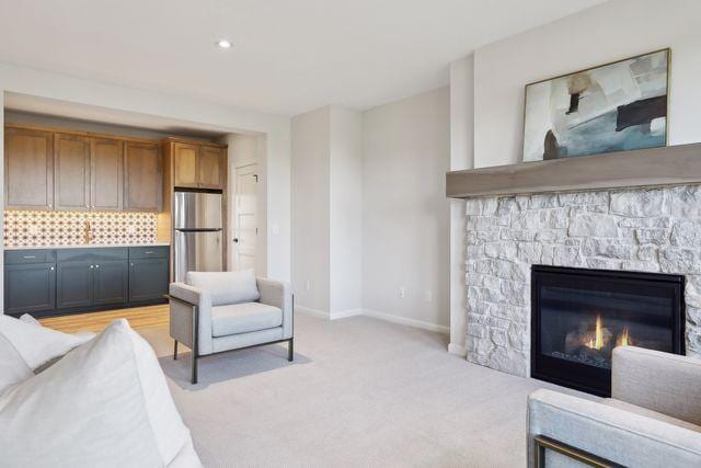 4029 Arbor Dr, Woodbury, MN 55129 - living area featuring light colored carpet, a stone fireplace, and baseboards