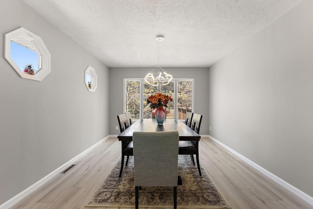 13804 Euclid Ct, Apple Valley, MN 55124 - dining room with light wood-style floors, a chandelier, a textured ceiling, and baseboards