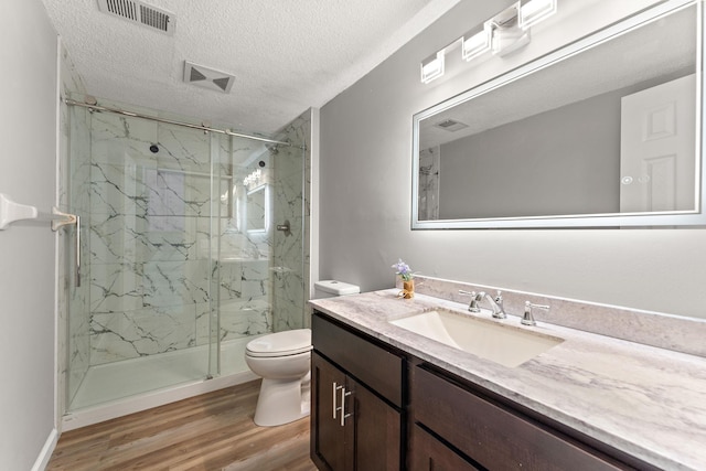 13804 Euclid Ct, Apple Valley, MN 55124 - full bathroom featuring toilet, vanity, a marble finish shower, wood finished floors, and a textured ceiling