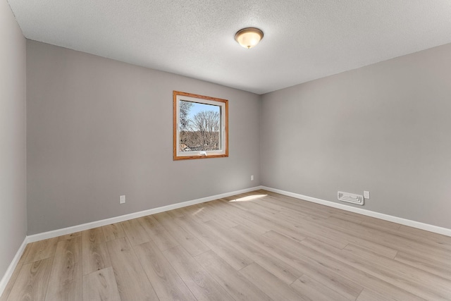 13804 Euclid Ct, Apple Valley, MN 55124 - spare room featuring light wood-style flooring, baseboards, and a textured ceiling