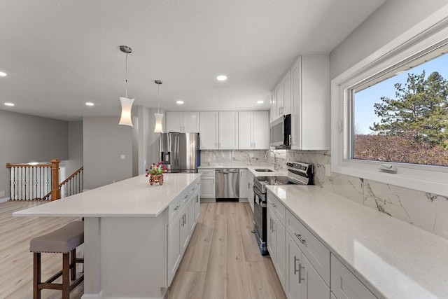 13804 Euclid Ct, Apple Valley, MN 55124 - kitchen with stainless steel appliances, light wood finished floors, backsplash, recessed lighting, and a kitchen island
