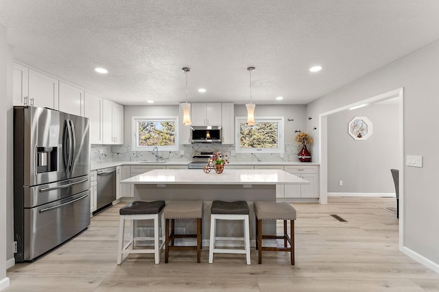 13804 Euclid Ct, Apple Valley, MN 55124 - kitchen with stainless steel appliances, light countertops, backsplash, white cabinetry, and recessed lighting