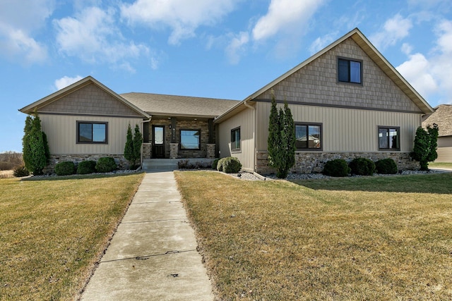 craftsman-style house featuring a porch, stone siding, and a front lawn