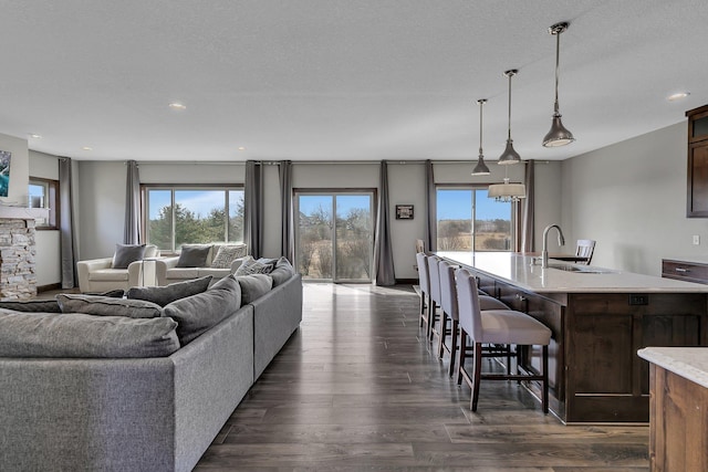 living area with dark wood-type flooring and recessed lighting