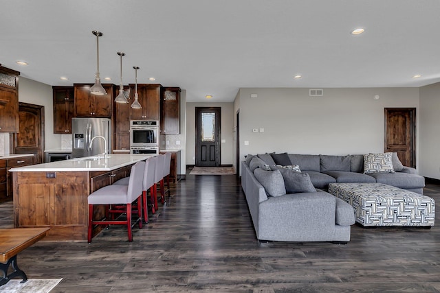 living area with recessed lighting, baseboards, visible vents, and dark wood-style floors